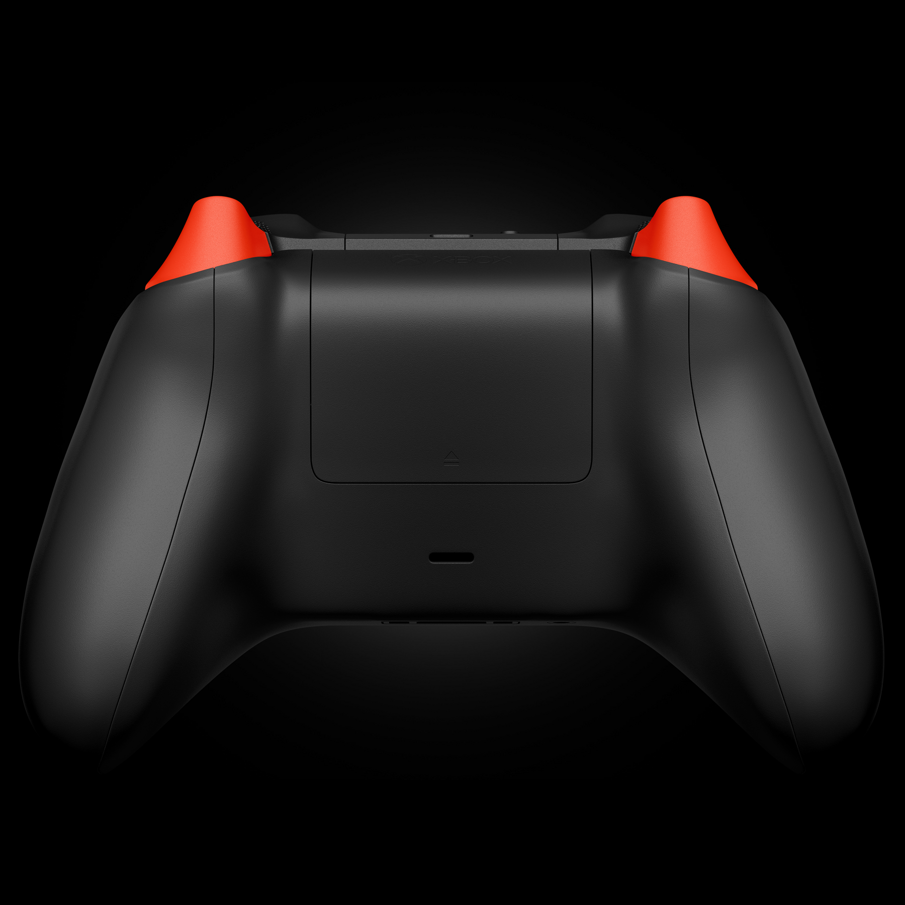 Rear view of a custom Xbox Series X controller with a matte black finish and bright orange trigger buttons.