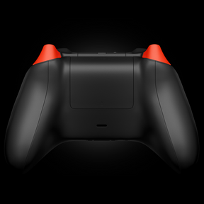 Rear view of a custom Xbox Series X controller with a matte black finish and bright orange trigger buttons.